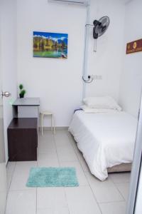 ein Schlafzimmer mit einem Bett, einem Schreibtisch und einem Tisch in der Unterkunft Just Stay Inn Guest House in Malakka