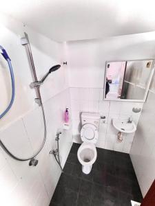 een badkamer met een douche, een toilet en een wastafel bij Just Stay Inn Guest House in Melaka