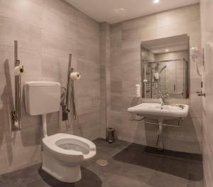 a bathroom with a toilet and a sink at Hotel NERU con Encanto in León