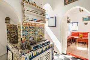 a kitchen with a stove and a tile wall at DAR YAMNA Maison typique Kasbah de Tanger in Tangier