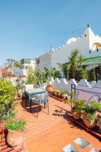 een patio met een tafel en een aantal potplanten bij DAR YAMNA Maison typique Kasbah de Tanger in Tanger