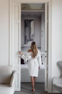 Una mujer con un vestido blanco caminando por una puerta en El Palauet Royal Suites, en Barcelona