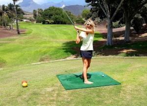 una mujer jugando golf en un putting green en Wellness-Penthaus am Meer en Palm-mar