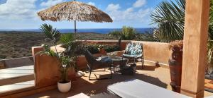 eine Terrasse mit einem Tisch, Stühlen und einem Sonnenschirm in der Unterkunft Wellness-Penthaus am Meer in Palm-mar