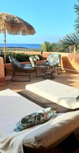 a patio with two beds and a table and chairs at Wellness-Penthaus am Meer in Palm-mar