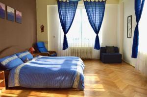 a bedroom with a bed and a window with blue curtains at Apartmán Nový Smokovec 75 in Nový Smokovec