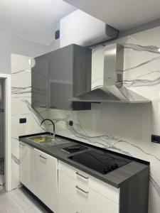 uma cozinha branca com um lavatório e um fogão em Apartments Villa Jelena em Vodice