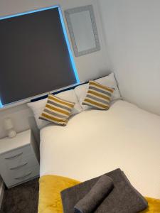 a bedroom with a bed with pillows and a tv at Stylish 2bed house in birmingham in Birmingham
