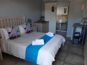 a bedroom with a bed with towels on it at Croeso Guest House in Langebaan +41 photos