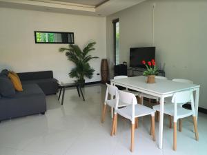a living room with a table and chairs and a couch at The Palm Villa Jomtien C7 in Jomtien Beach