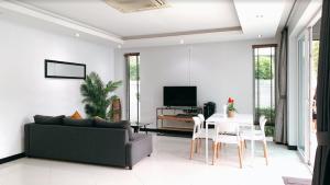 un salon avec un canapé et une table dans l'établissement Pool Villa Pattaya Jomtien Beach - Palm Oasis C7, à Jomtien Beach