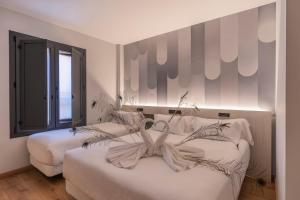 a bedroom with two beds with a bow on them at Hotel NERU con Encanto in León