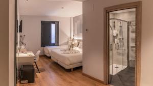 a bedroom with a bed and a bathroom with a mirror at Hotel NERU con Encanto in León