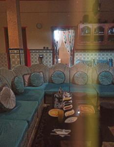 a living room with a blue couch and a table at Quiet House Tamraght in Agadir