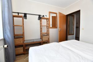 ボルクムにあるStrandhus-4のベッドルーム1室(ベッド1台付)、木製の棚が備わります。