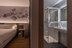 a bedroom with a bed and a glass shower at Hotel NERU con Encanto in Le&oacute;n