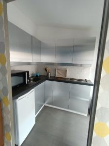 een kleine keuken met witte kasten en een magnetron bij Studio Flow Libourne in Libourne