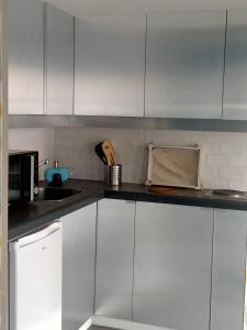 een keuken met witte kasten en een aanrecht bij Studio Flow Libourne in Libourne
