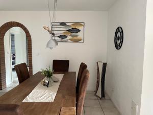 a dining room with a table and chairs and a clock at Spitzenbergblick in Reichensachsen