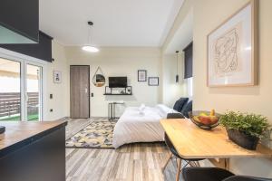 1 dormitorio con cama, mesa y cocina en Petralona Stylish Penthouse, en Atenas