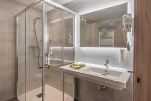 a bathroom with a sink and a shower at Hotel NERU con Encanto in León