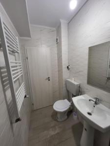 uma casa de banho branca com um WC e um lavatório em A (cozy) place like HOME em Bucareste