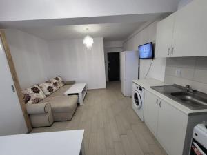 uma cozinha e sala de estar com um sofá e uma mesa em A (cozy) place like HOME em Bucareste
