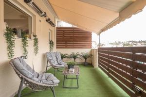 un patio con 2 sillas y una mesa en el balcón en Petralona Stylish Penthouse, en Atenas