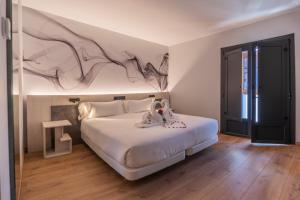 a bedroom with a bed with a painting on the wall at Hotel NERU con Encanto in León