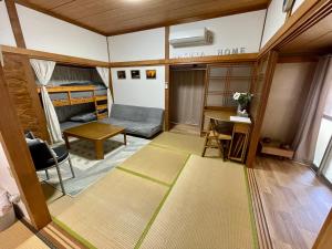 uma sala de estar com um sofá, uma cama e uma mesa em Sakurahome&El Flamenquito em Muroto