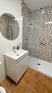 ein Badezimmer mit einem weißen Waschbecken und einer Dusche in der Unterkunft Apartamento T2 com Terraço grande in Quarteira