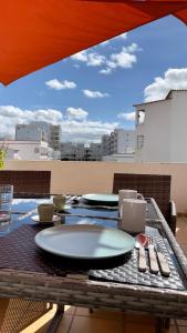 einen Tisch mit Tellern und Küchenutensilien auf einer Terrasse in der Unterkunft Apartamento T2 com Terraço grande in Quarteira