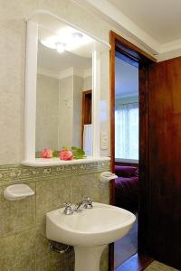 uma casa de banho com um lavatório e um espelho em Tango B&B em Ushuaia