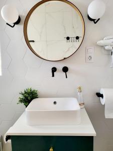 a bathroom with a white sink and a mirror at House of Chess Luxury Villa in Satu Mare