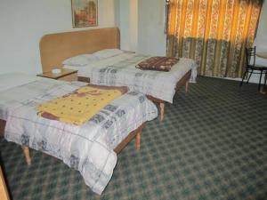 a hotel room with two beds and a table at Asia Hotel in Amman