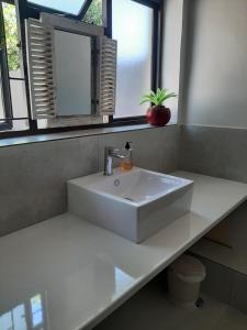 a white sink in a bathroom with a window at Croeso Guest House in Langebaan