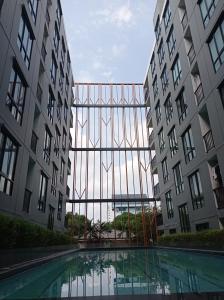 バンコクにあるBangKok Eyesの2棟の建物の間のプールの景色を望めます。