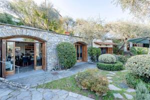 a stone house with a garden and a patio at Villa Renetta with Swimming pool and Jacuzzi and parking in Rapallo