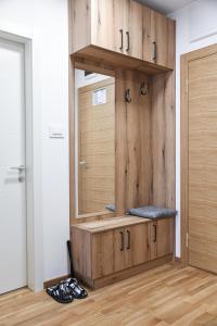 uma sala de vestir com um espelho e um armário de madeira em ANNA 2 Apartment free parking em Novi Sad