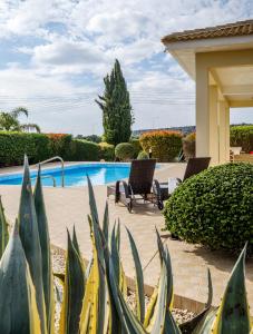 un patio con 2 sillas y una piscina en Cape Greco Villa Anastel 2 en Ayia Napa