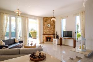 a living room with a couch and a fireplace at Cape Greco Villa Anastel 2 in Ayia Napa