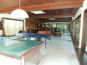 una habitación con dos mesas de ping pong. en Casa Luxuosa a 50m da Praia em Sirinhaém en Sirinhaém