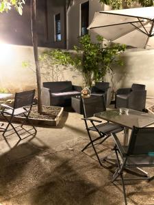 patio ze stołem, krzesłami i parasolem w obiekcie LE PORTE DI PALERMO w mieście Palermo