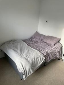 an unmade bed in a bedroom with a white wall at 03 Glasgow Flat in Glasgow