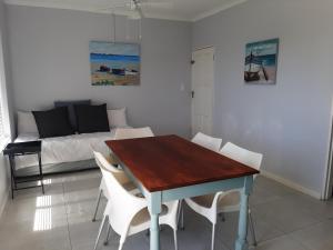 a dining room with a table and chairs and a bed at Croeso Guest House in Langebaan