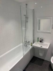a white bathroom with a shower and a sink at 03 Glasgow Flat in Glasgow