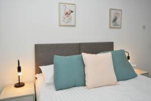 a bedroom with a bed with blue and white pillows at Lowther House by YourStays in Stoke on Trent