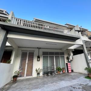 Dieses weiße Haus verfügt über einen Balkon und eine Terrasse. in der Unterkunft Rania D'Mawar Homestay 2 1/2 Tingkat KLIA in Sepang