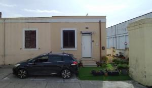 a black car parked in front of a house at Al centro del porto in Civitavecchia