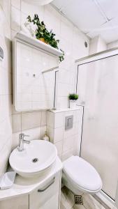 a white bathroom with a sink and a toilet at Venum in Varna City